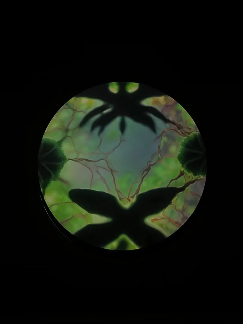 A projection mixing leaf shadows with red, vein like patterns