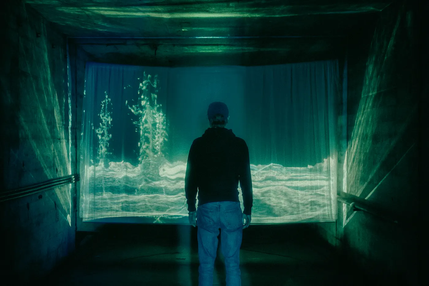 A visitor facing a projected landscape of chemical waste